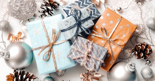 Wrapped gifts surrounded by Christmas ornaments and pine cones