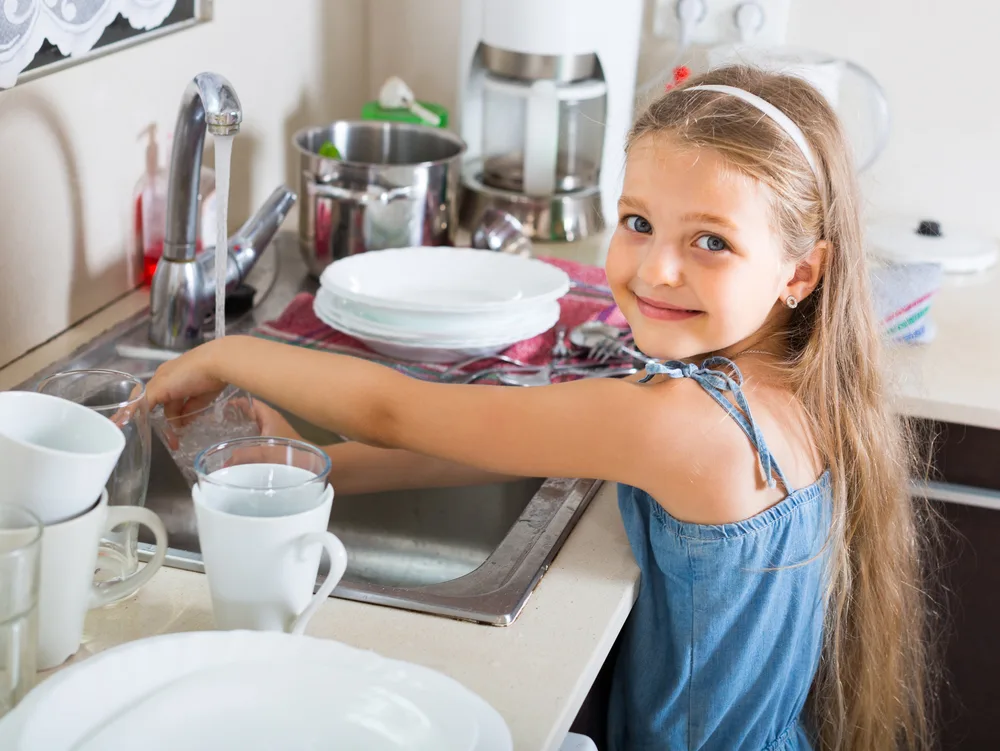Child washing dishes