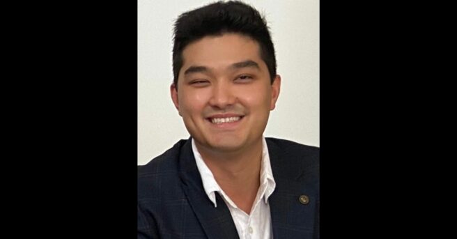 headshot of person smiling and wearing a suit