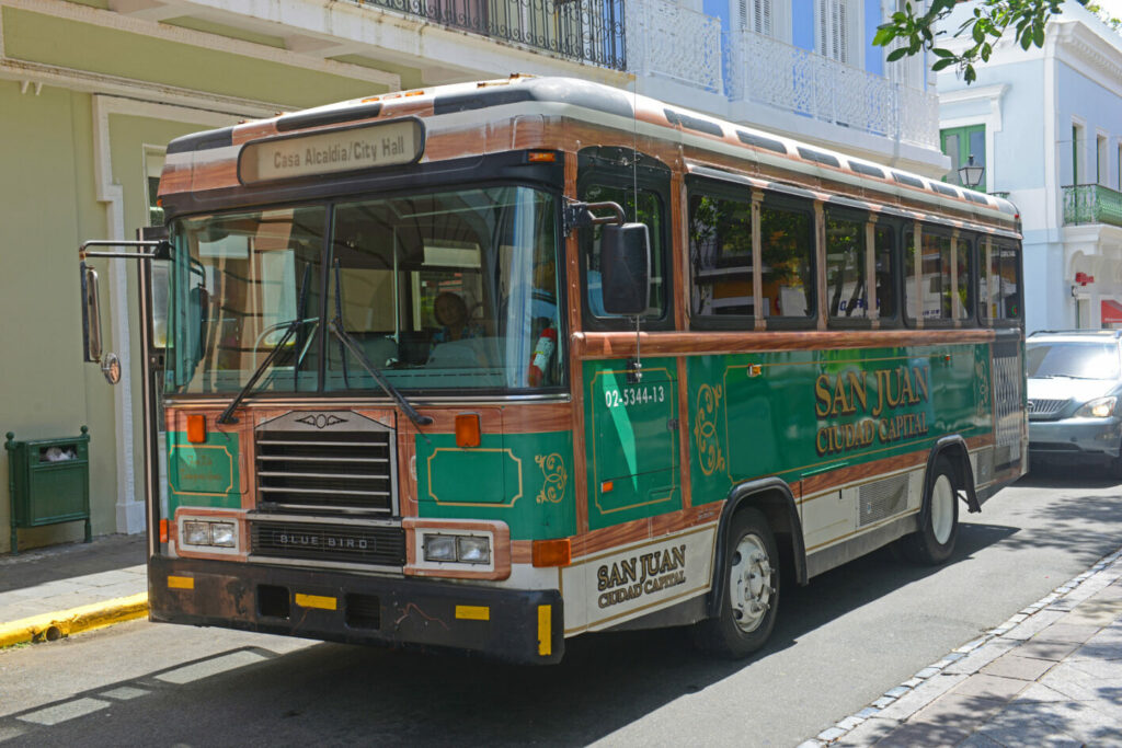 San Juan bus traveling in front of colorful buildings