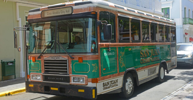 San Juan bus traveling in front of colorful buildings