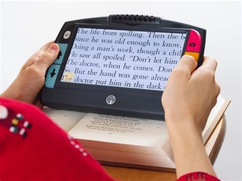 person holding Juno, a portable video magnifier with print enlarged on screen