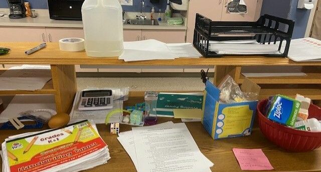 An image of various supplies an OT would use with your child on a desk, including handwriting materials, bags, and glue.