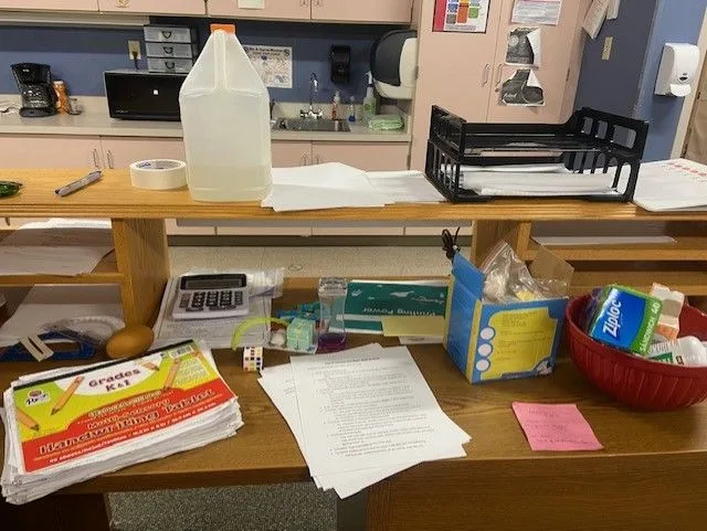 An image of various supplies an OT would use with your child on a desk, including handwriting materials, bags, and glue.