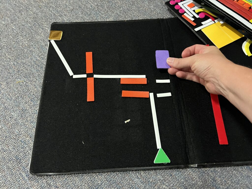 A tactile map and someone adding a square to represent a building.