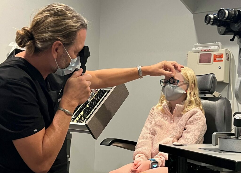 Doctor giving a vision exam to a young girl