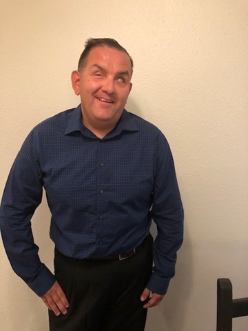 man with short, dark hair wearing dark blue button down shirt