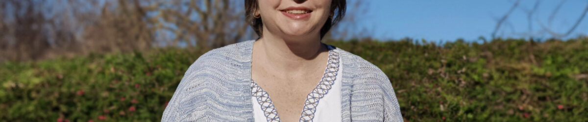 A woman with dark brown hair smiles for the camera.