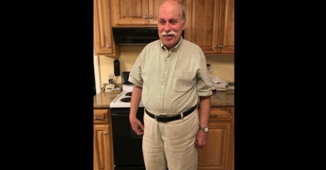 Individual in business casual standing in a kitchen