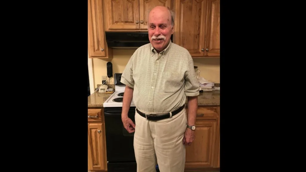 Individual in business casual standing in a kitchen