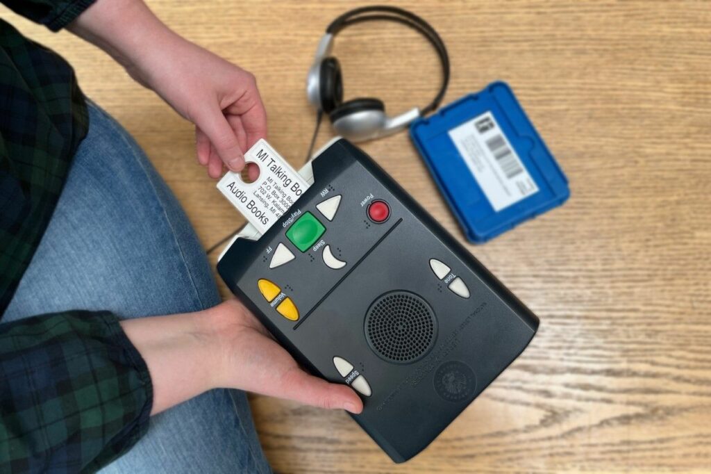 A person putting the talking library card into the reader.