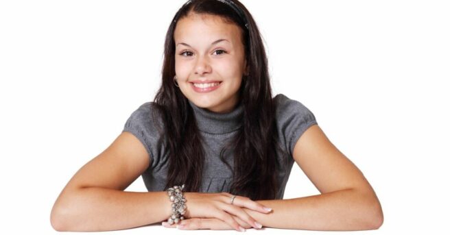 Teenage girl smiling and folding arms