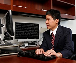 Man sitting at desk working on computer. 