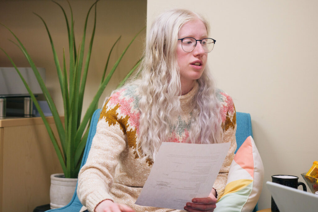 Student with glasses holding a paper