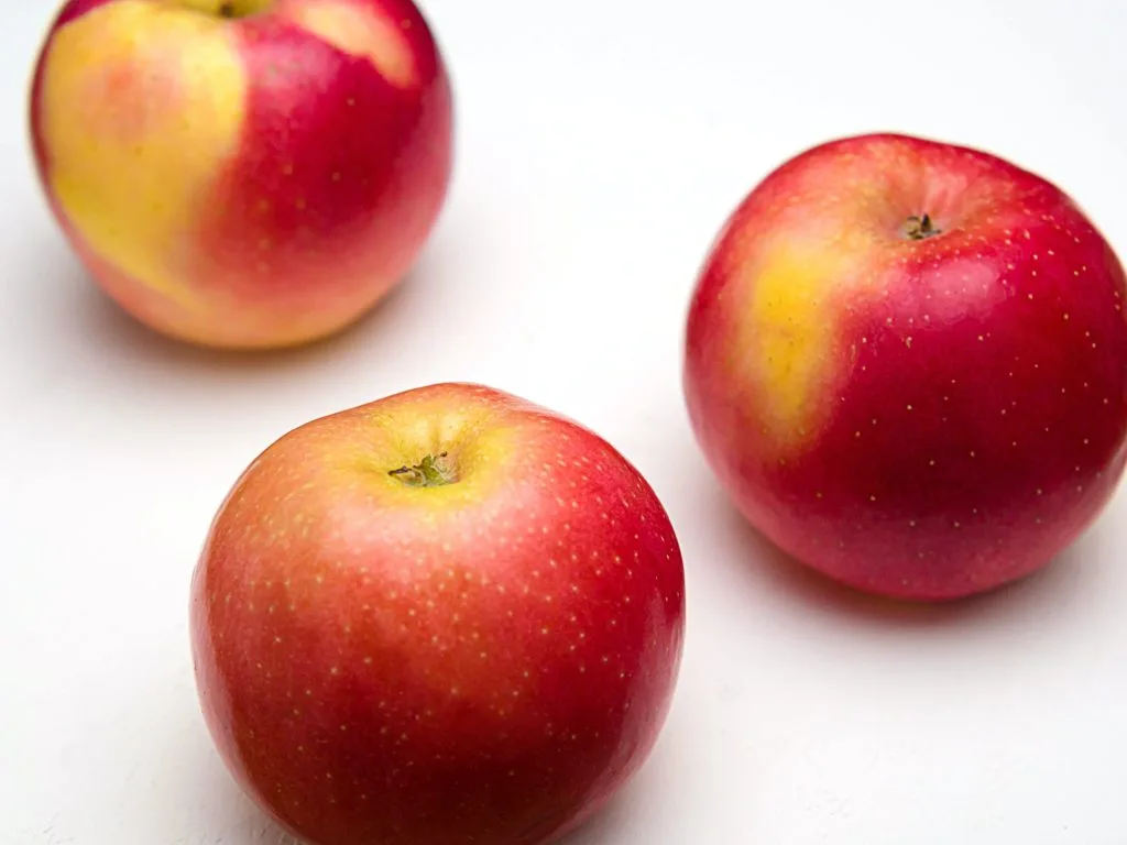 Three red apples on a white background