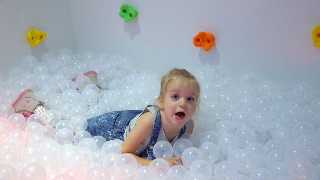 Young girl playing in ball pit