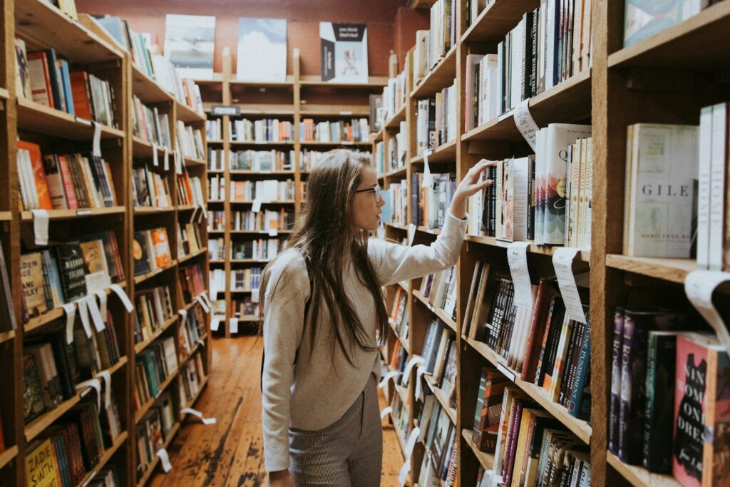 College student with eyeglasses searches for book in campus library