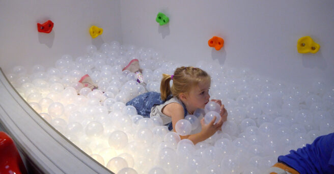 Young girl playing in ball pit