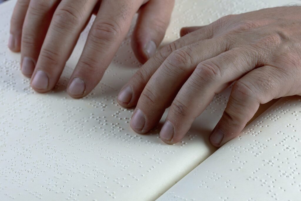 Fingers touching a braille page