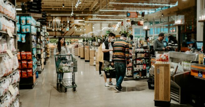 grocery store checkout aisle with a line of customers