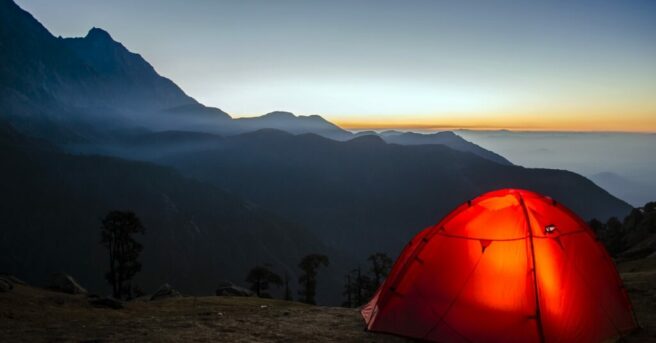 An illuminated tent in the mountains