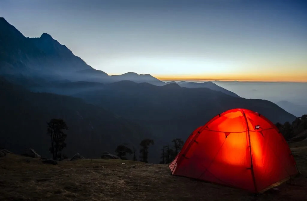 An illuminated tent in the mountains