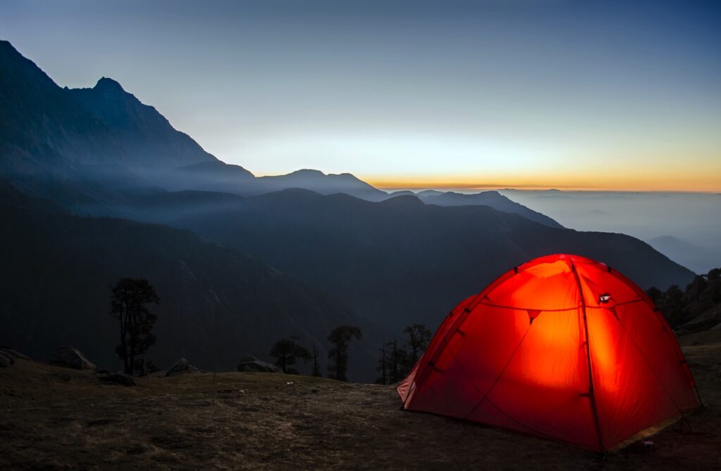 An illuminated tent in the mountains