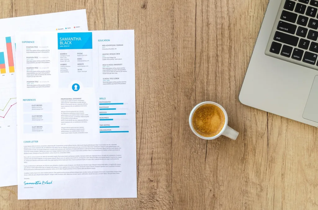 resume on a desk with a laptop and cup of coffee