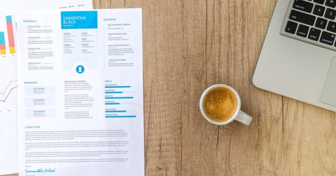resume on a desk with a laptop and cup of coffee