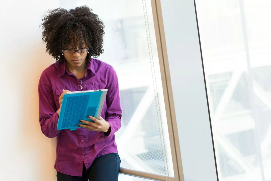 woman wearing glasses in office working on a tablet