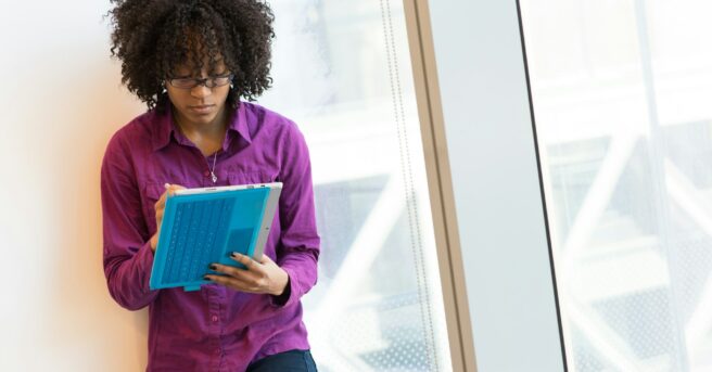 woman wearing glasses in office working on a tablet