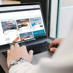 Persons hands typing on a laptop