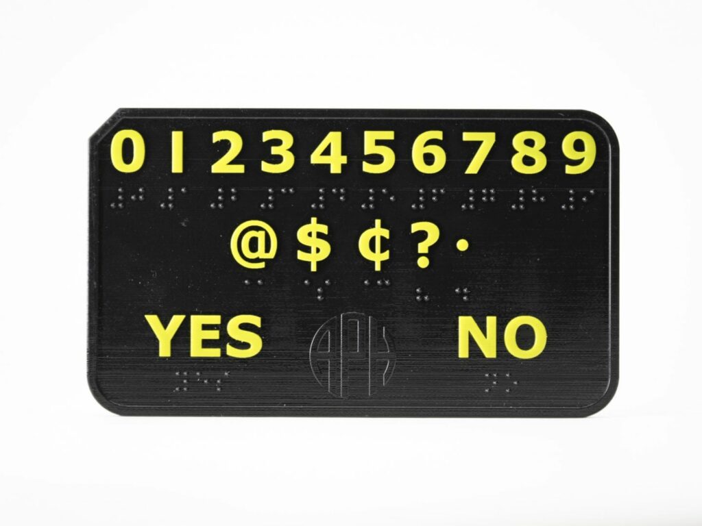 DeafBlind communicator device with 0-9 across the top. on the middle line: @$cents ? and the period sign. Yes and no are on the bottom line. all in braille