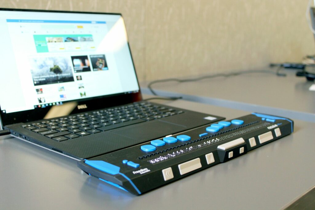 Photo of a computer with a refreshable braille display. Photo by Elizabeth Woolner on Unsplash.