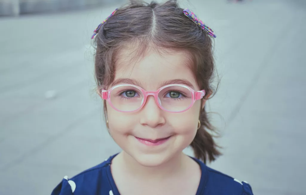 Photo of young girl with round pink glasses