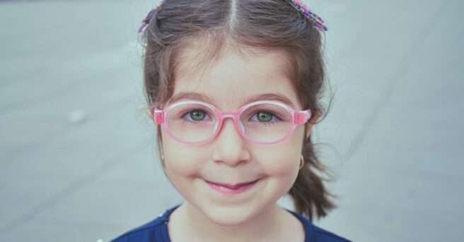 Photo of young girl with round pink glasses