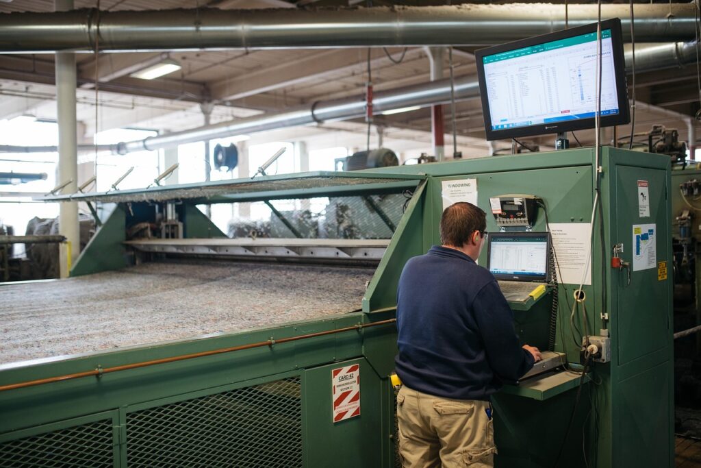 individual wearing glasses, working in a manufacturing facility