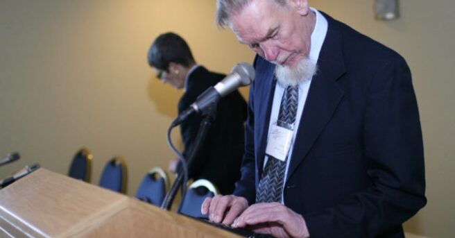photo of Gil Johnson standing at a lectern.