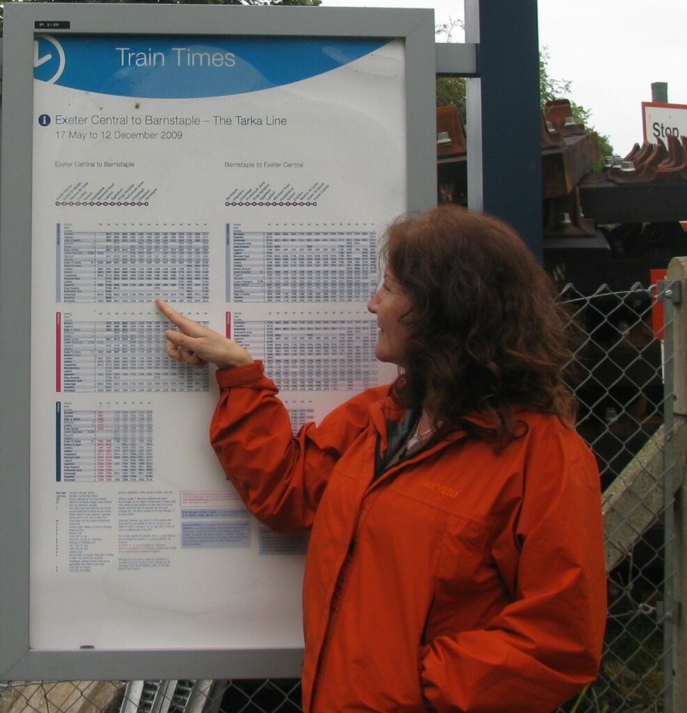 a person looking at a train schedule
