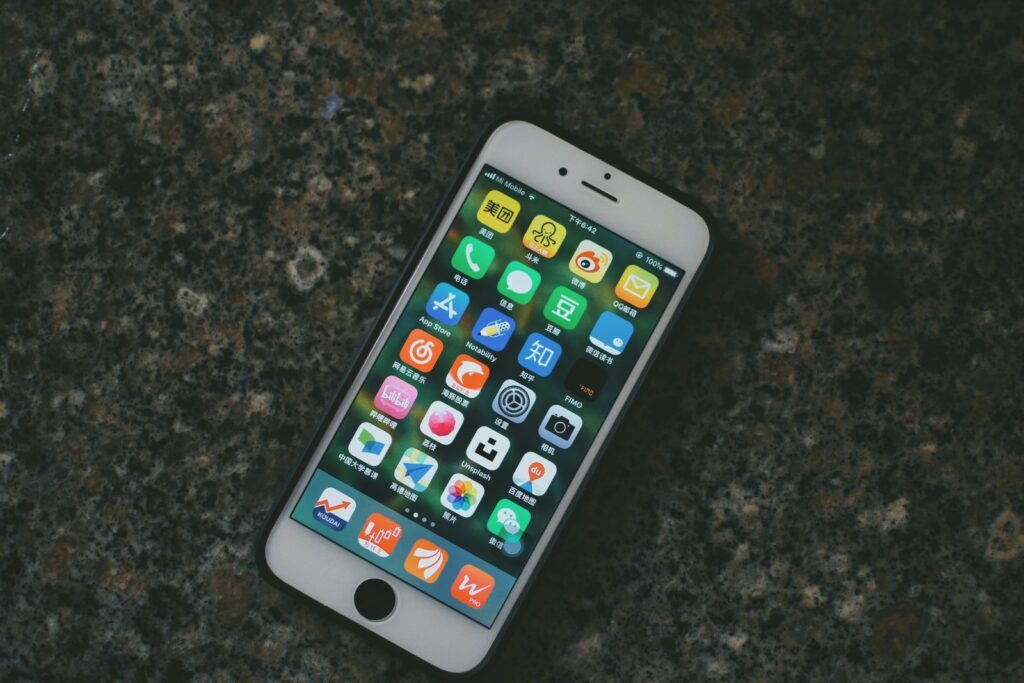 iPhone home screen with apps. Photo by Jizhidexiaohailang on Unsplash