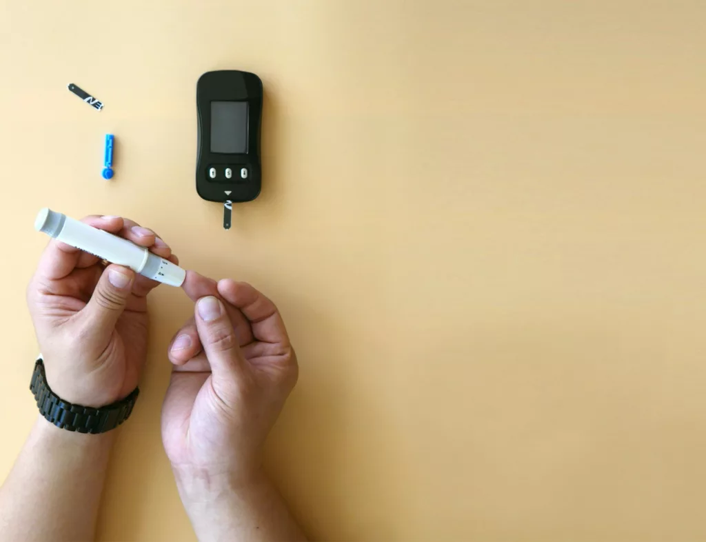 closeup of glucose monitor and person sticking finger