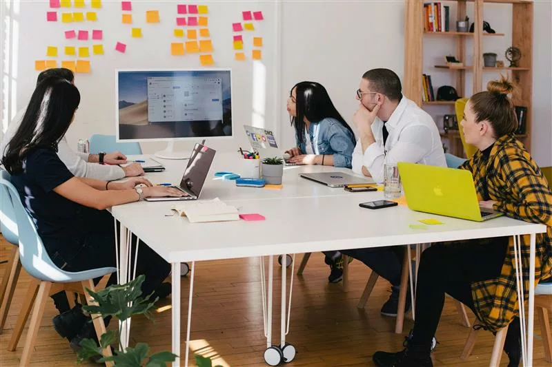 group of employees sit at a conference table for a presentation