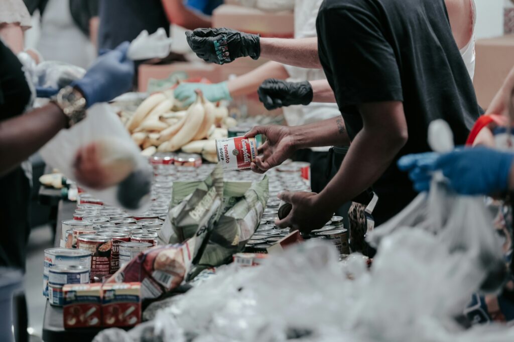 individuals at a food drive pack canned food in bags