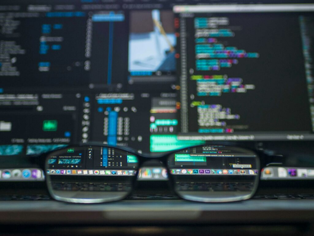 code visible on a computer screen through eyeglasses