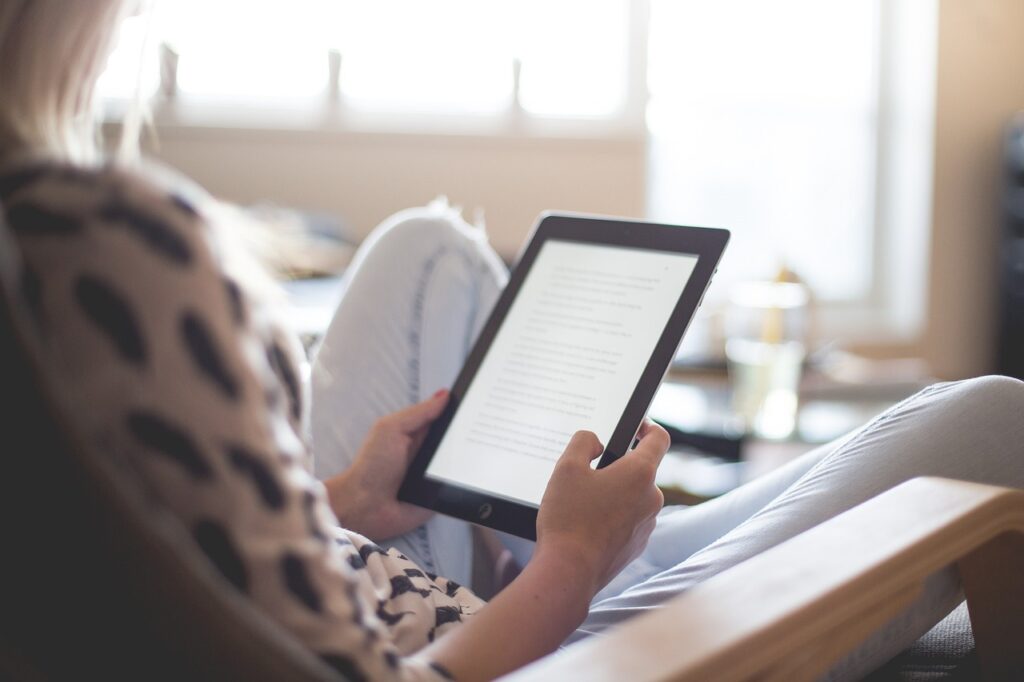 person sitting on the couch and holding an eReader