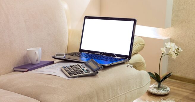 laptop, phone, and calculator on a living room couch