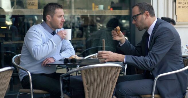 Photo of two men meeting for coffee outside a business
