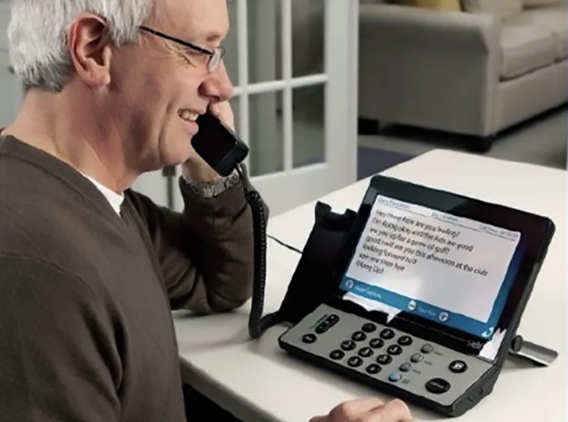 Man using captel to converse on the telephone. 