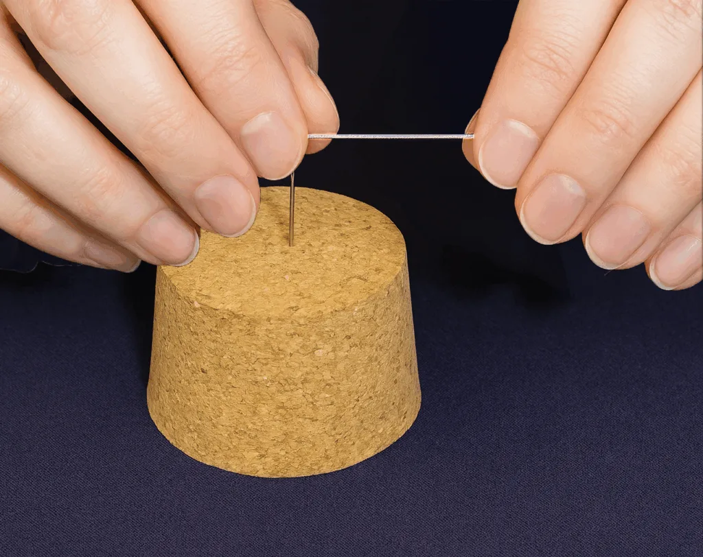Guide the taut thread to the top of the needle with one of your index fingers