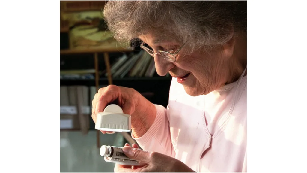 woman look at pill bottle through a magnifier
